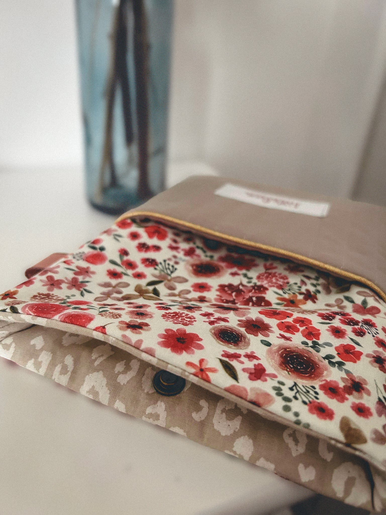 Pochette à liseuse fleurie, tons rouges et beige